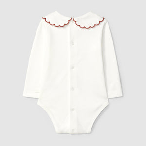 White onesie with red scalloped collar on a light gray background