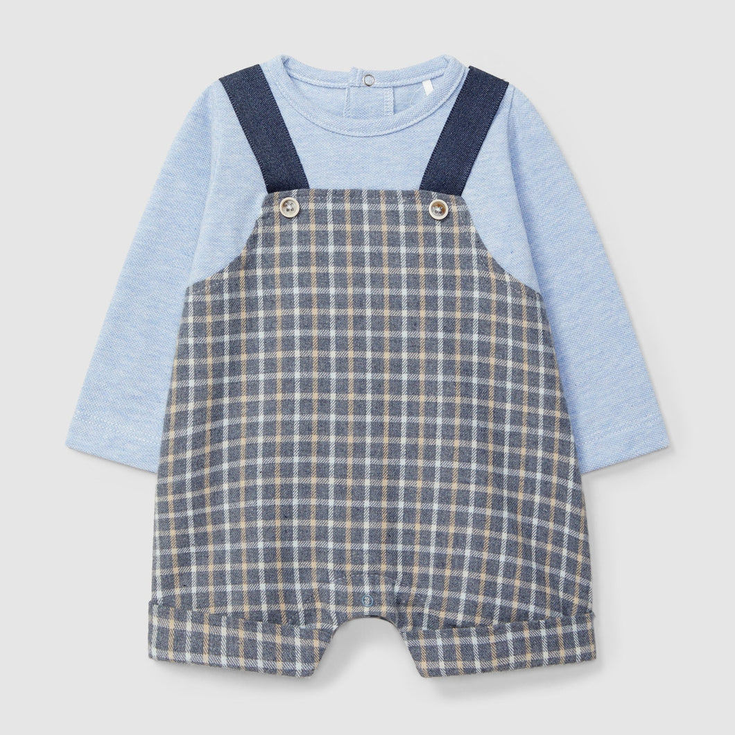 Baby outfit with blue long-sleeve shirt and checkered overalls on a light gray background