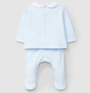 Baby outfit with light blue shirt and white pants on a beige background