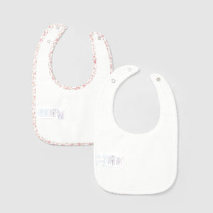 Two baby bibs with floral trim on a light gray background