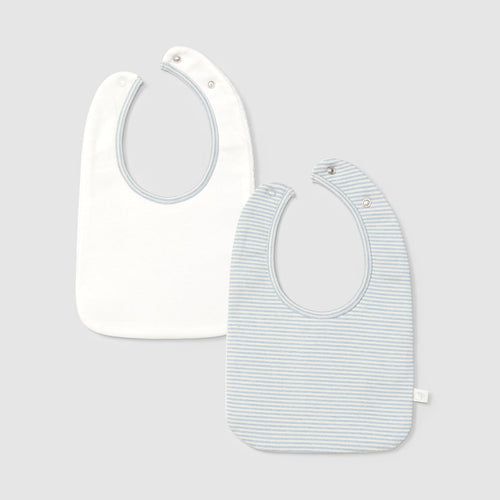 Two baby bibs, one plain white and one with a subtle pattern, on a light gray background.