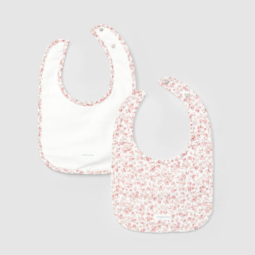 Two baby bibs with floral pattern on a light gray background