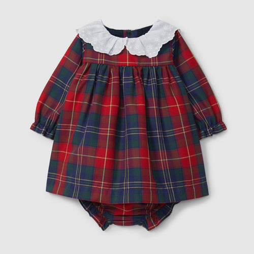 Red and blue plaid baby dress with white collar on a light gray background