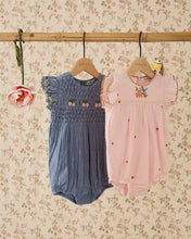 將圖片載入圖庫檢視器 Two baby rompers, one blue and one pink, hanging on a rack against a floral wallpaper background.
