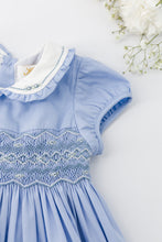 將圖片載入圖庫檢視器 Kidiwi Héloïse smocked dress in Cornflower poplin with ruffled details and a fitted bodice, displayed on a hanger.
