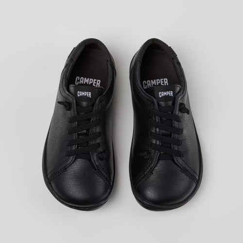 Pair of black sneakers on a light gray background