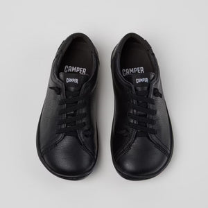 Pair of black sneakers on a light gray background