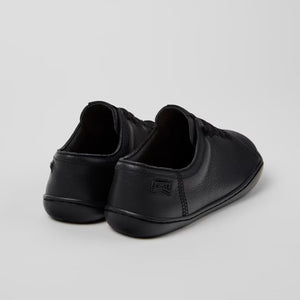 Pair of black slip-on shoes on a light gray background