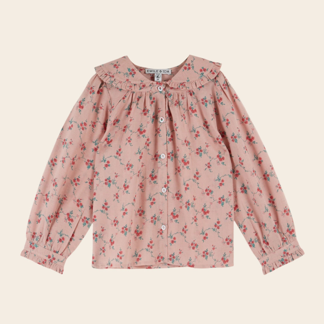 Pink floral blouse on a beige background