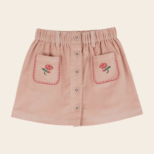 Pink skirt with floral embroidery on a beige background