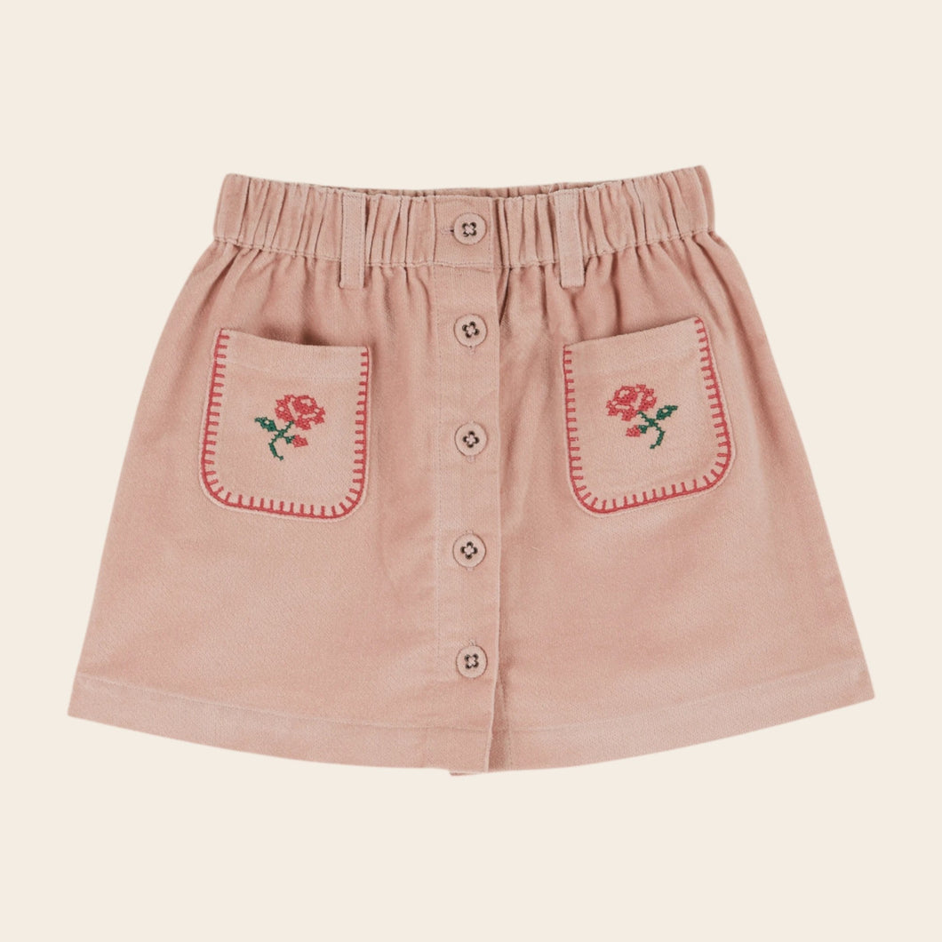 Pink skirt with floral embroidery on a beige background