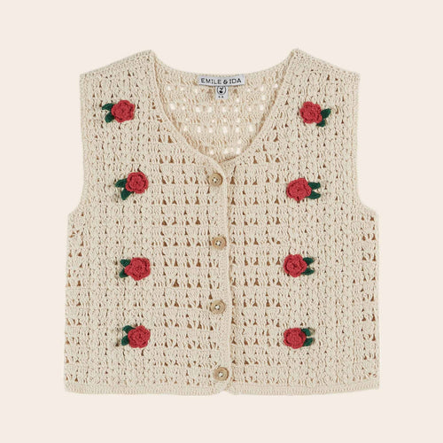 Crocheted vest with rose decorations on a beige background
