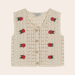 Crocheted vest with rose decorations on a beige background