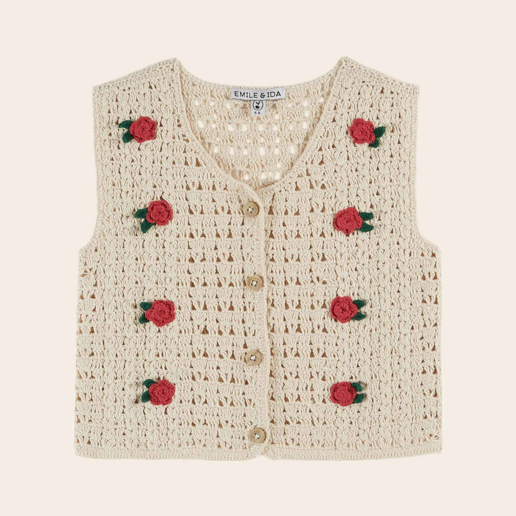 Crocheted vest with rose decorations on a beige background