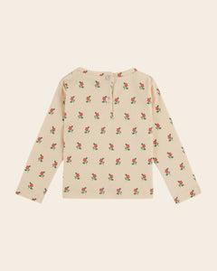 Beige long-sleeve shirt with red floral pattern on a beige background