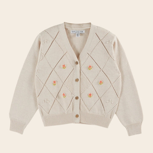 Beige cardigan with floral patterns on a beige background
