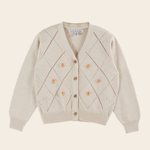 Beige cardigan with floral patterns on a beige background