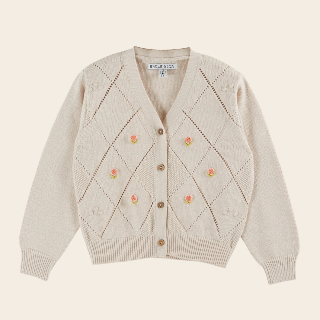Beige cardigan with floral patterns on a beige background