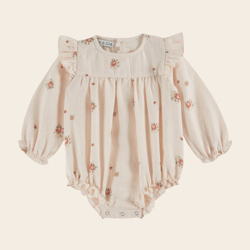 Baby romper with floral pattern on a light beige background