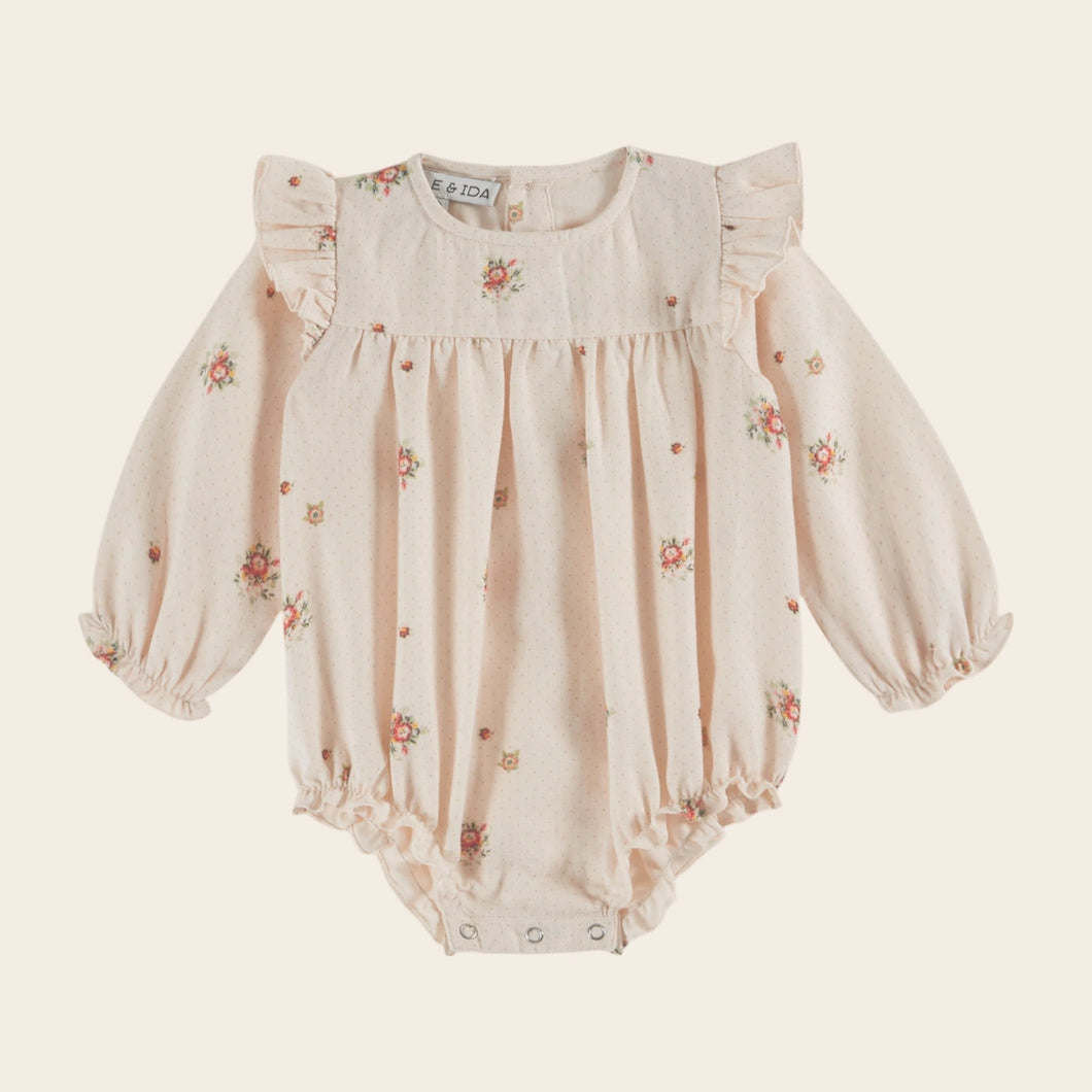 Baby romper with floral pattern on a light beige background