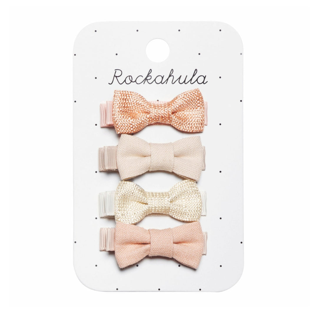 Set of four pink and beige bow hair clips on a Rockahula branded card.