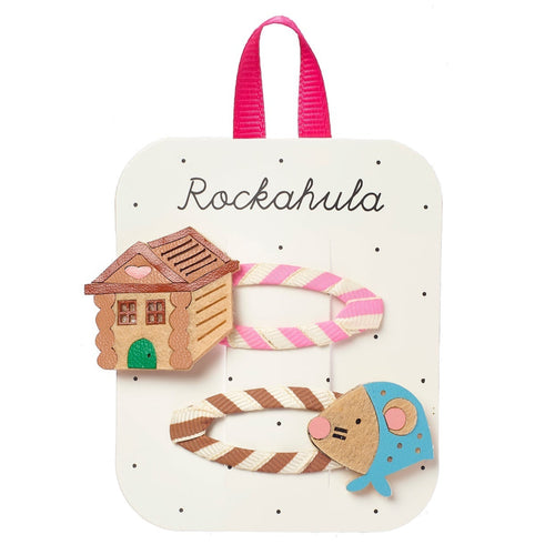 Children's book with wooden house, candy cane, and mouse illustration on a white background with 'Rockahula' branding.