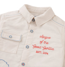 Load image into Gallery viewer, Beige shirt with red embroidered text on a white background