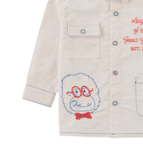 Load image into Gallery viewer, Beige shirt with embroidered character design on a white background