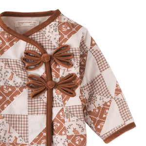 Baby outfit with checkered pattern and brown accents on a white background