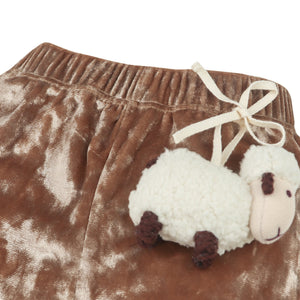 Brown shorts with a white sheep plush toy on a white background