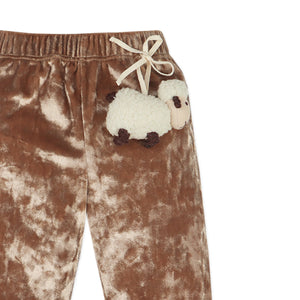 Brown velvet pants with a white sheep patch on a white background