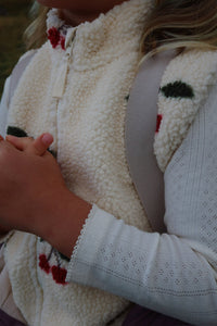 Close-up of a person wearing a white fleece jacket with colorful patterns.