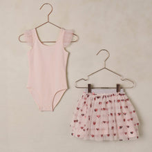 Load image into Gallery viewer, Pink sleeveless top and heart-patterned skirt on hangers against a beige wall.