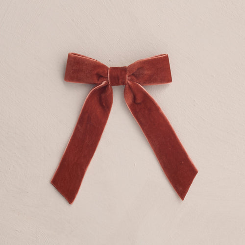 Red velvet bow on a beige background