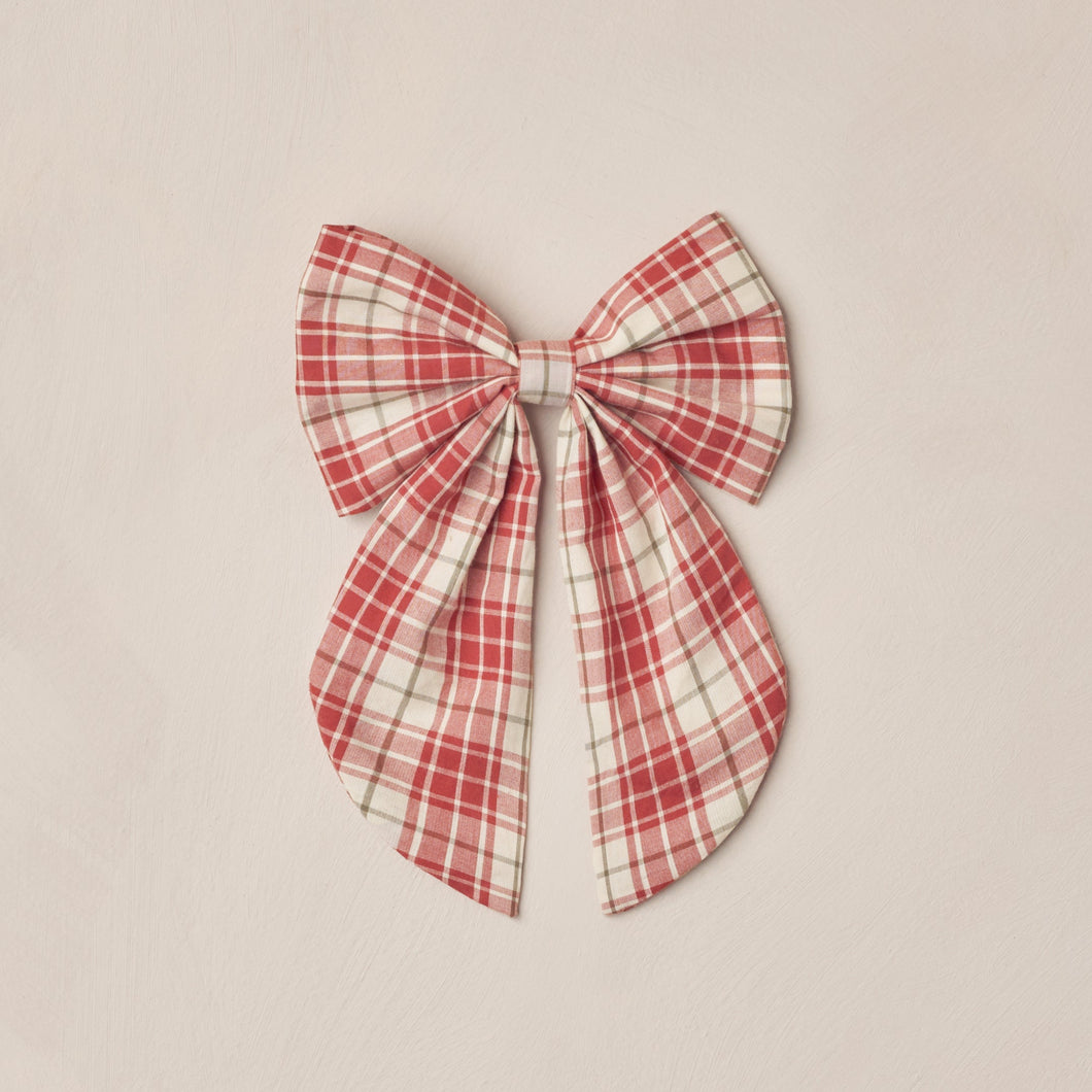 Red and white plaid bow on a beige background