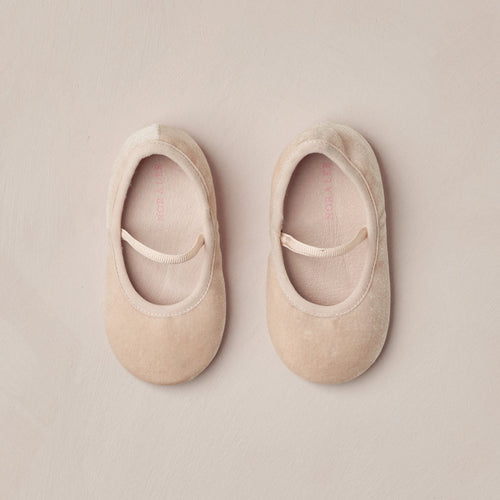 Pair of beige ballet flats on a beige background