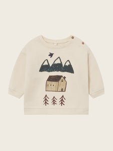 Beige sweater with mountain and cabin design on a white background