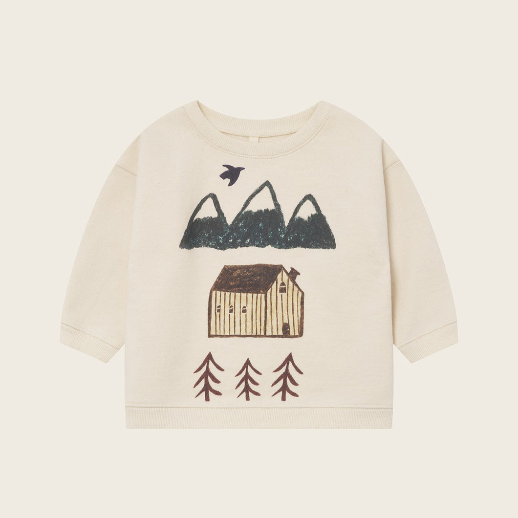 Children's sweater with nature-themed design on a beige background
