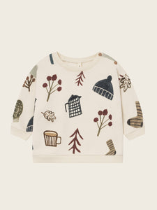 Children's sweater with winter-themed illustrations on a beige background