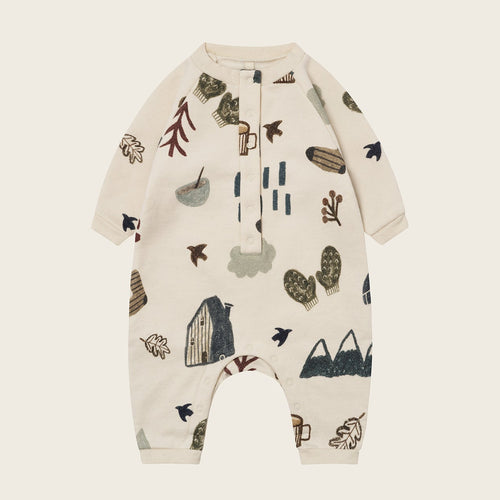 Baby romper with nature-themed print on a beige background