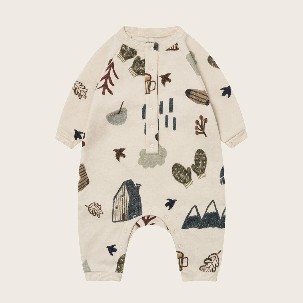 Baby romper with nature-themed print on a beige background