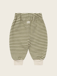 Green and beige striped baby pants on a light beige background
