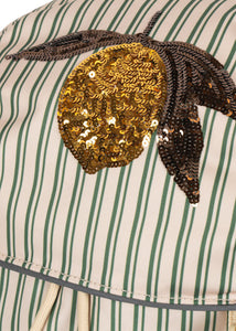 Close-up of a sequined pineapple patch on a striped fabric background