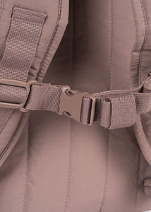 Close-up of a brown backpack with a buckle and strap