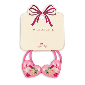 Pink heart-shaped hair ties with cartoon characters on a beige card with a pink bow, branded 'Lavish Angel'.