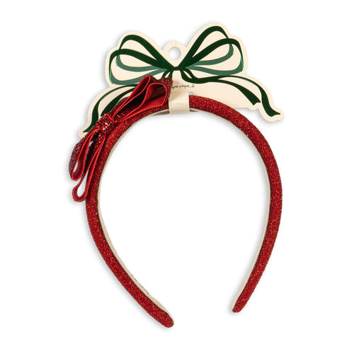 Red headband with green bow on a white background