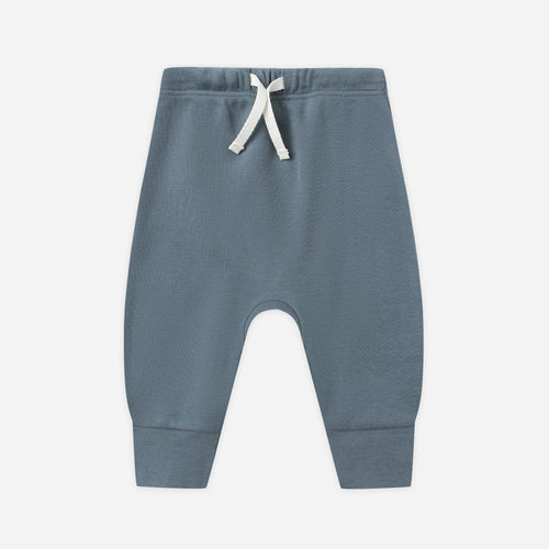Blue baby pants with a white drawstring on a light gray background