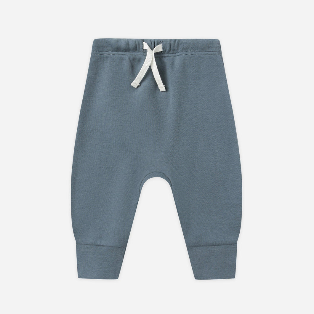 Blue baby pants with a white drawstring on a light gray background