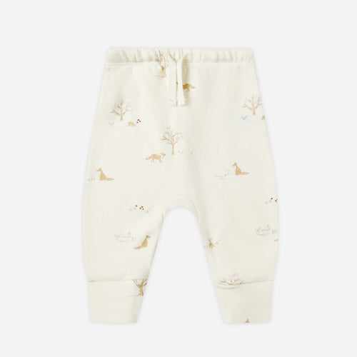 Cream-colored baby pants with small pattern on a white background