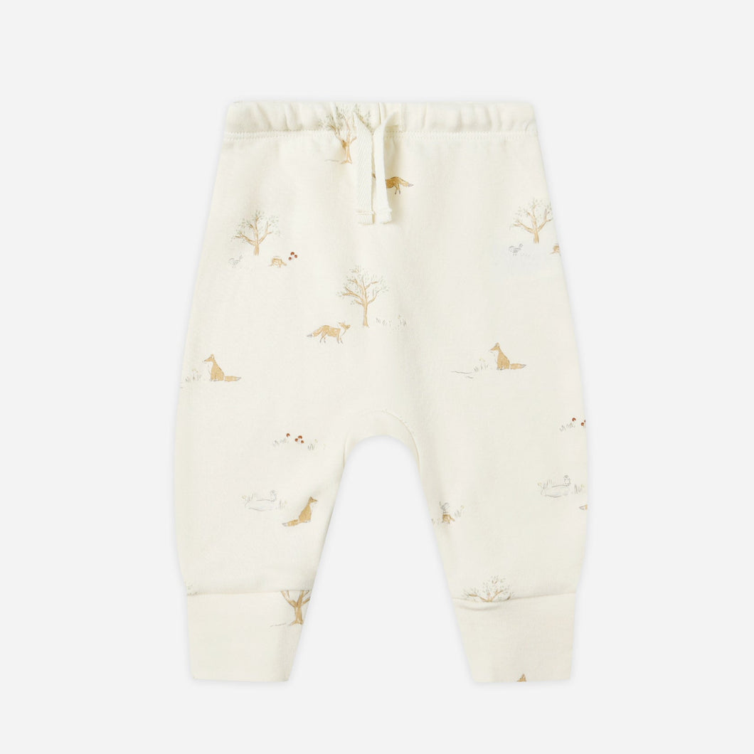 Cream-colored baby pants with small pattern on a white background